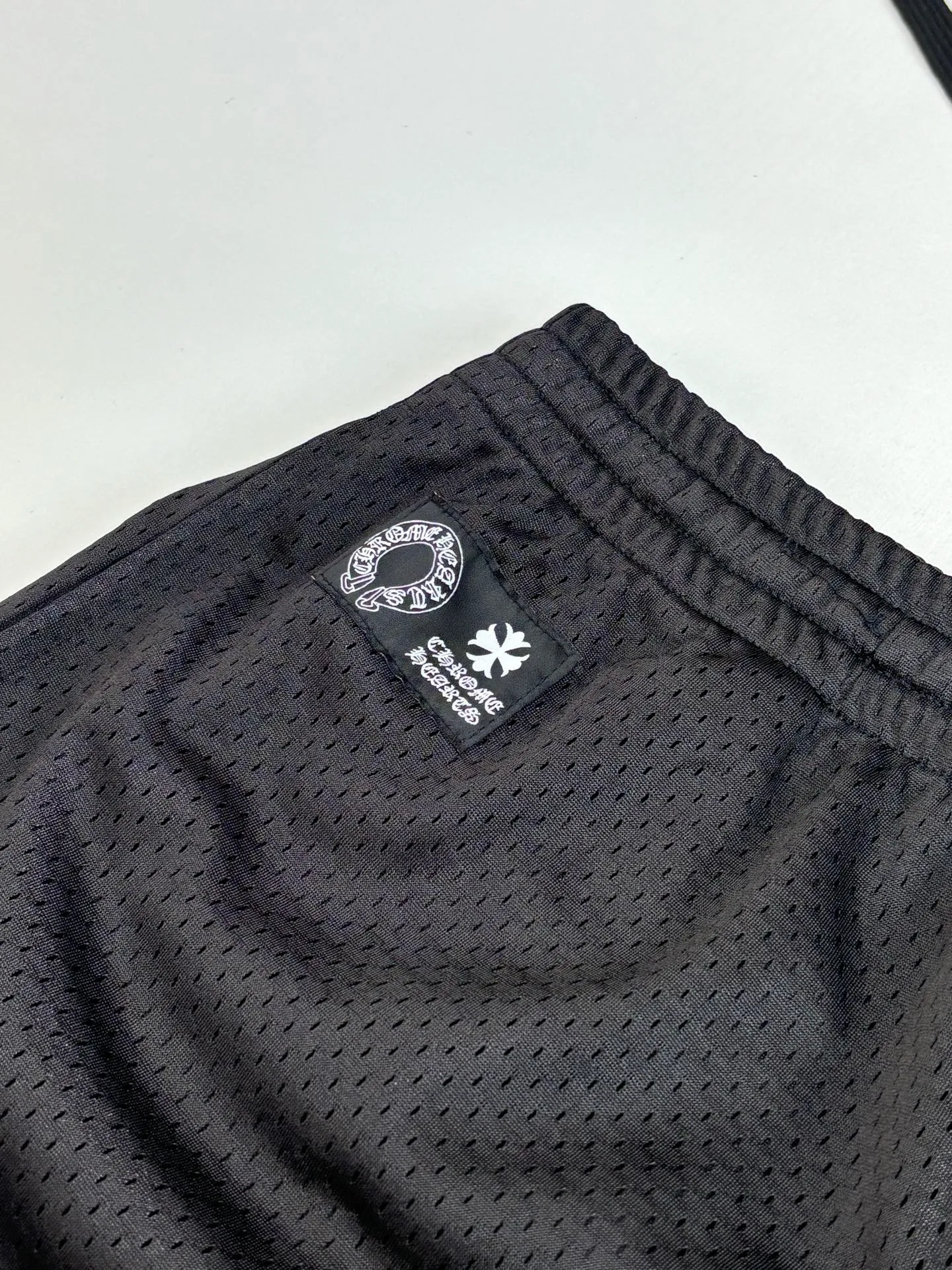 P340 Chrome Heart*/Chrome Heart Sanskrit mesh ice hockey suit straight trousers. The original version was purchased for 15,989 and developed. The fabric is made of custom weaving and dyeing technology. It is made of selected black mesh fabric, showing a unique sports style. The fabric has been specially treated to provide excellent breathability and comfort while maintaining a crisp and structured look. The double-layer design structure enhances the overall texture and makes the wearing experience more three-dimensional and full. The brand's iconic patterns are printed in many places, and high-precision printing technology is used to ensure that the patterns are clear and sharp. The silver printing has a glitter effect, showing charming luster changes under different lights. All printings undergo strict color difference control to ensure accurate color reproduction. The silver-plated pattern design on the sleeve arms is particularly eye-catching, showing the brand's consistent dark luxury style. In terms of details, the latest custom-woven labels are used, and the workmanship is exquisite. The overall shape is designed for both men and women, with both fashion and practicality. This T-shirt perfectly combines sports elements with high fashion craftsmanship, making it the brand's iconic street style item.  Size：S/M/L
